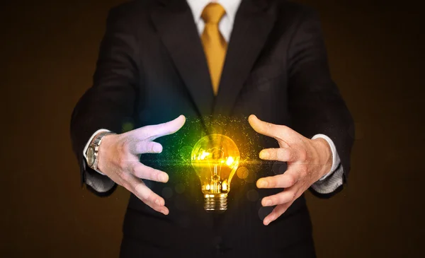 Businessman holding light bulb — Stock Photo, Image