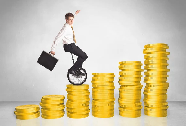 Business man riding monocycle up on coin graph — Stock Photo, Image