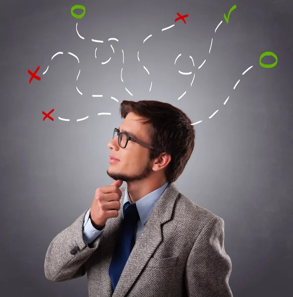 Young man thinking with marks overhead — Stock Photo, Image