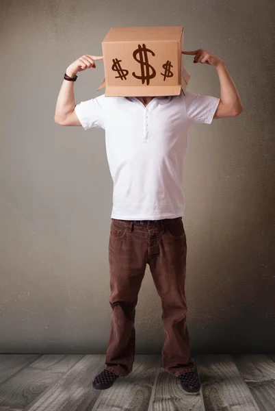 Jeune homme gesticulant avec une boîte en carton sur la tête avec un dollar — Photo