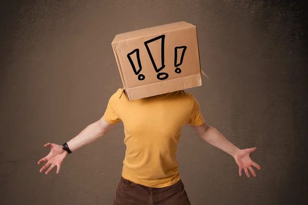 Jeune homme gesticulant avec une boîte en carton sur la tête à l'exclam — Photo