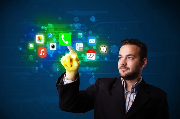 Handsome businessman pressing colorful mobile app icons with bok — Stock Photo, Image