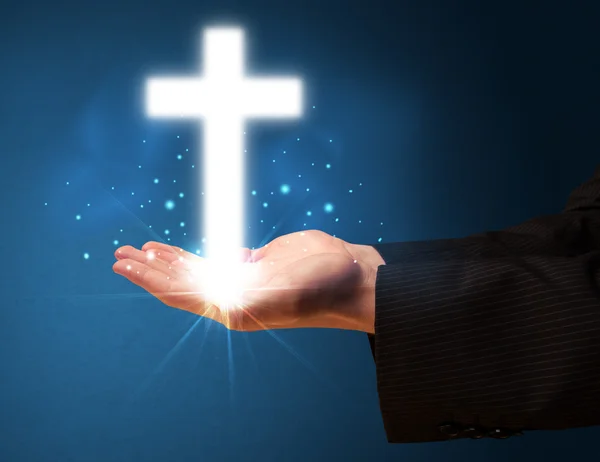 Glowing cross in the hand of a businessman — Stock Photo, Image