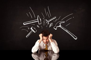 Depresyondaki işadamı çekiç izlerinin altında oturuyor