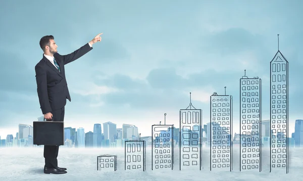 Business man climbing up on hand drawn buildings in city — Stock Photo, Image