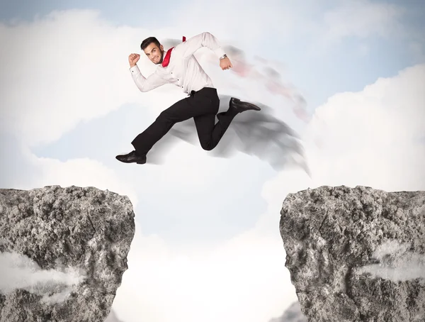 ギャップのある岩を飛び越える面白いビジネスマン — ストック写真