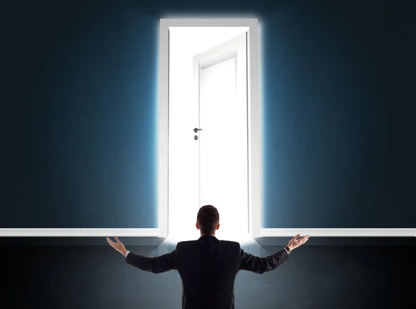 Business man looking at big bright opened door — Stock Photo, Image