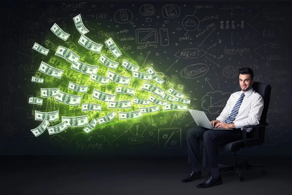 Businessman sitting in chair holding laptop with dollar bills co — Stock Photo, Image