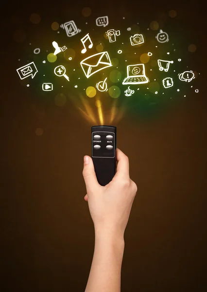 Hand with remote control and social media icons — Stock Photo, Image