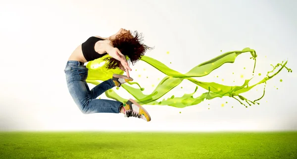 Söt flicka hoppar med grön abstrakt flytande klänning — Stockfoto