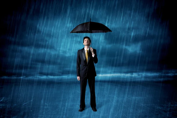 Egy esőben álló üzletember esernyővel. — Stock Fotó