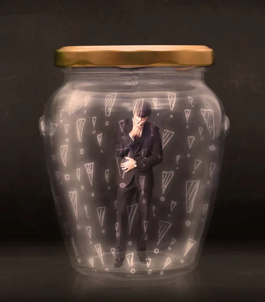 Business man trapped in jar with exclamation marks concept — Stock Photo, Image