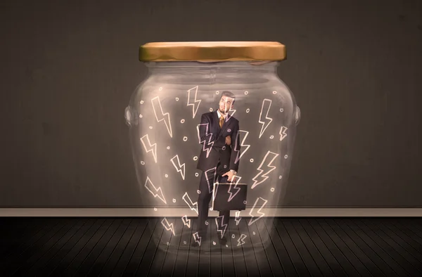 Homme d'affaires à l'intérieur d'un bocal en verre avec des dessins de foudre concept — Photo
