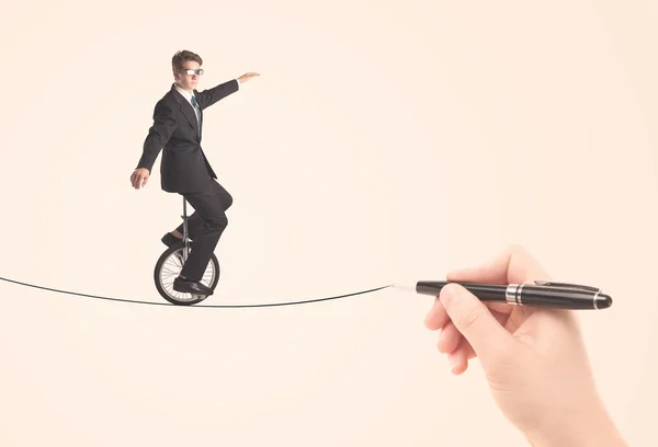 Businessman riding monocycle on a rope drawn by hand — Stock Photo, Image