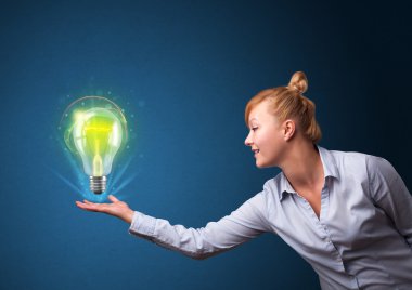 bir iş kadını elinde parlayan ampul