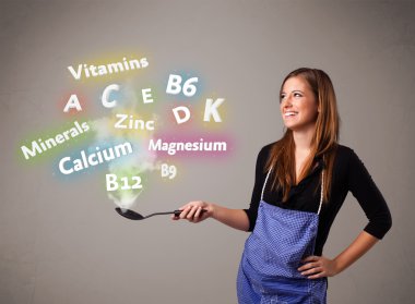 Genç bir kadın vitamin ve mineral pişiriyor.