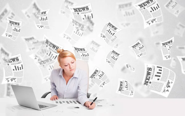 Business woman at desk with stock market newspapers — Stock Photo, Image