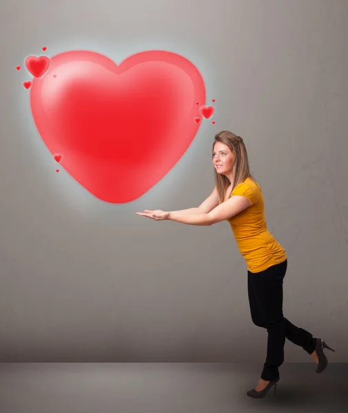 Jovem senhora segurando adorável 3d coração vermelho — Fotografia de Stock