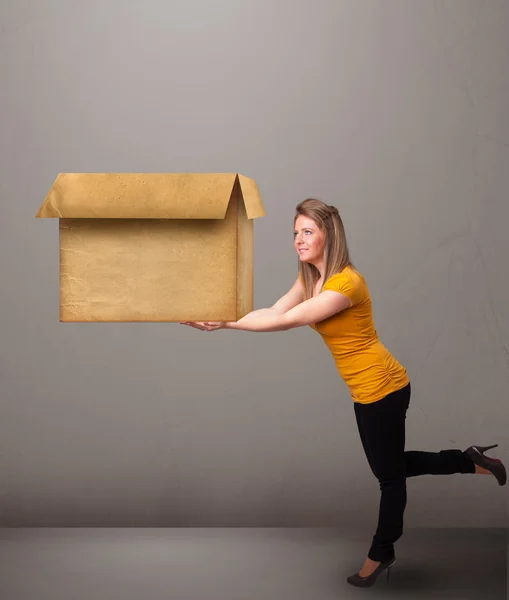 Jovem segurando uma caixa de papelão vazia — Fotografia de Stock