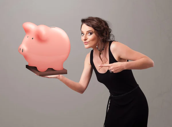 Young girl holding a huge savings piggy bank — Stock Photo, Image