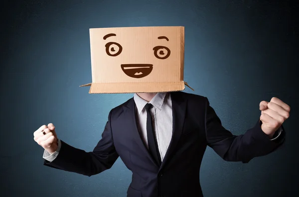 Businessman gesturing with a cardboard box on his head with smil — Stock Photo, Image