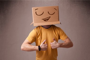 genç adam smiley ile kafasına bir karton kutu ile el hareketi