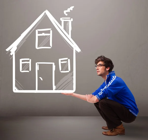 Young boy holding a huge drawn house — Stock Photo, Image