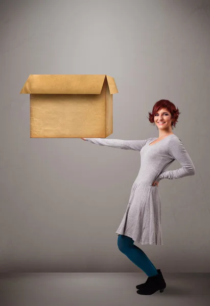 Young woman holding an empty cardboard box — Stock Photo, Image