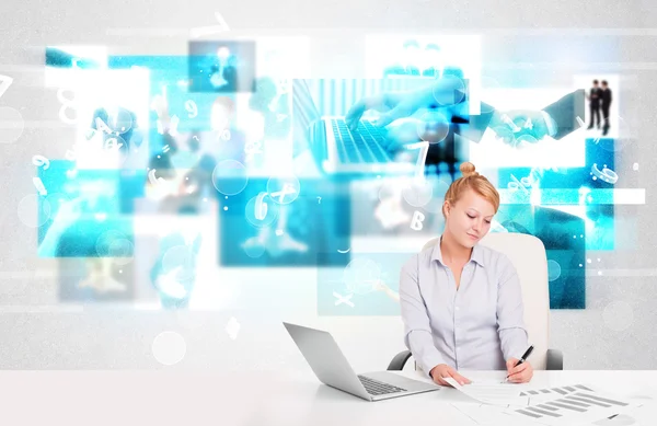 Business person at desk with modern tech images at background Stock Picture