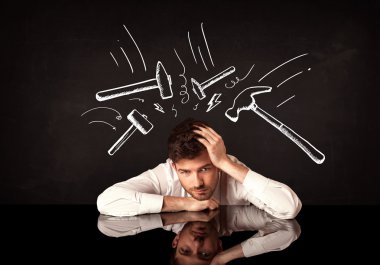 Depresyondaki işadamı çekiç izlerinin altında oturuyor