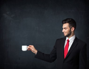 Beyaz bir bardak tutan işadamı