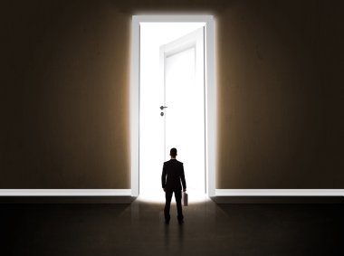 Büyük parlak kapıyı açan bir iş adamı.