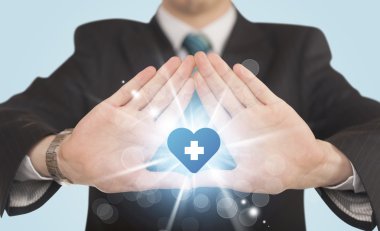 Eller mavi haçlı bir kalp yaratıyor.