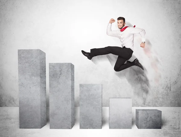 Successful business man jumping over charts on background — Stock Photo, Image