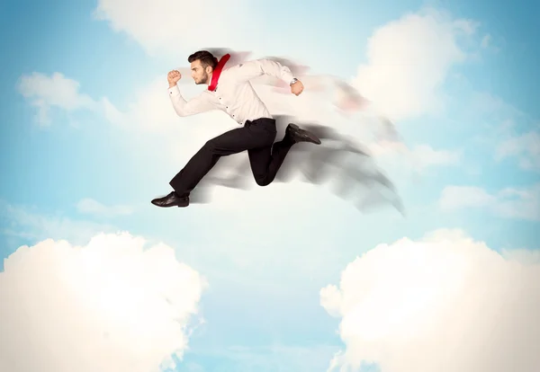 Affärsperson hoppar över moln i himlen — Stockfoto