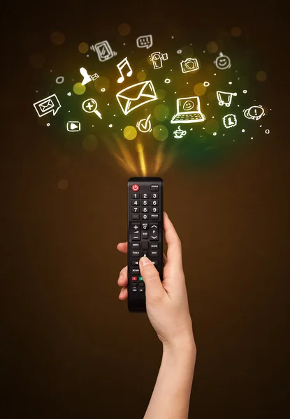 Hand with remote control and social media icons — Stock Photo, Image