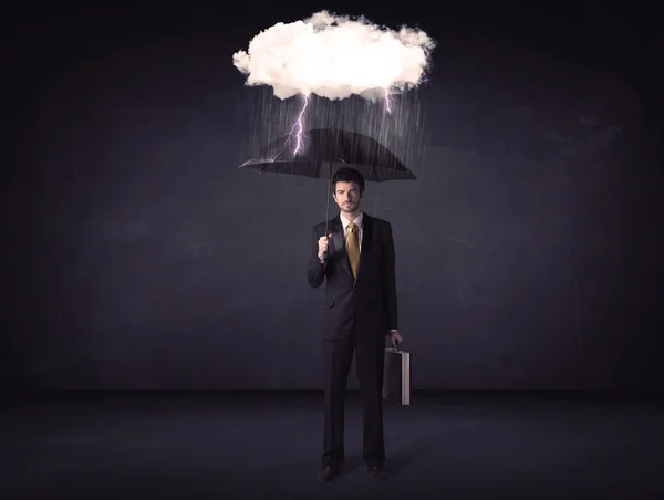 Empresário de pé com guarda-chuva e pouca nuvem de tempestade — Fotografia de Stock