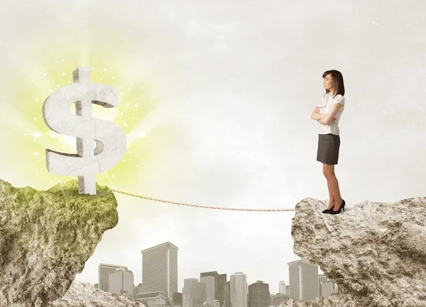 Businesswoman on rock mountain with a dollar mark — Stock Photo, Image