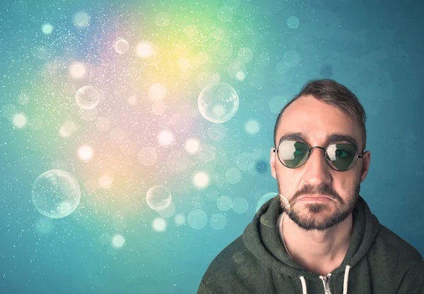 Young man with sunglasses and bokeh colourful lights — Stock Photo, Image