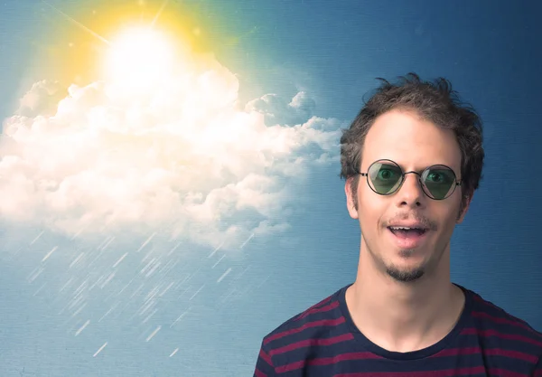 Junger Mann blickt mit Sonnenbrille auf Wolken und Sonne — Stockfoto