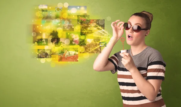 Cute girl blowing colourful glowing memory picture concept — Stock Photo, Image