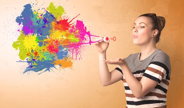 Cute girl blowing colorful splash graffiti — Stock Photo, Image