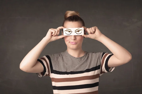 Young person holding paper with angry eye drawing — Stock Photo, Image