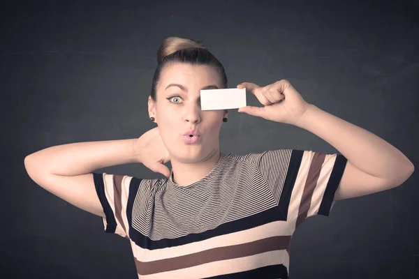 Pretty girl holding blank copy space paper at her eyes — Stock Photo, Image