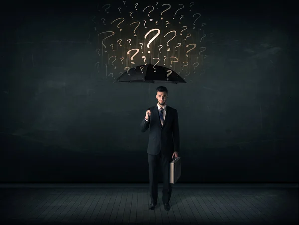 Homme d'affaires avec parapluie et beaucoup de points d'interrogation tirés — Photo