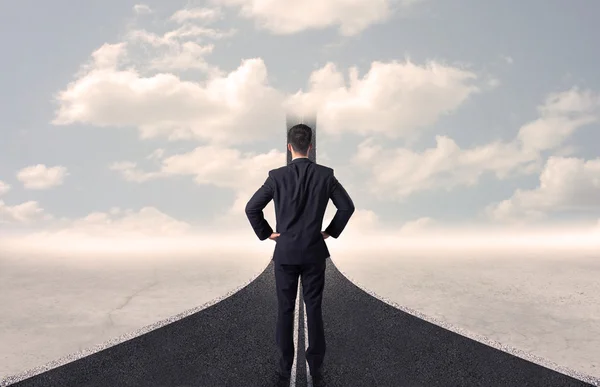 Businessman looking at 3d road that goes up in the sky — Stock Photo, Image