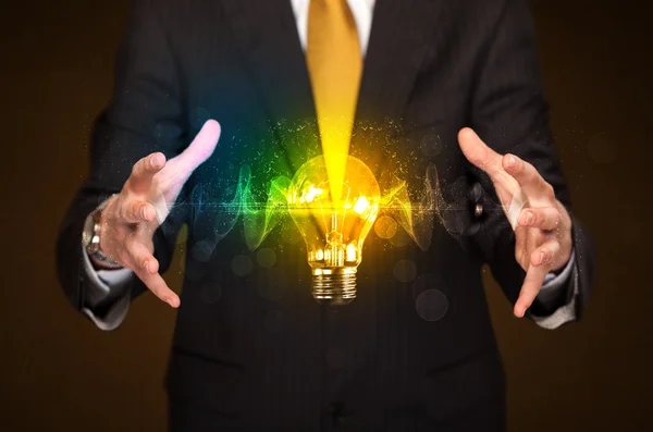 Businessman holding light bulb — Stock Photo, Image