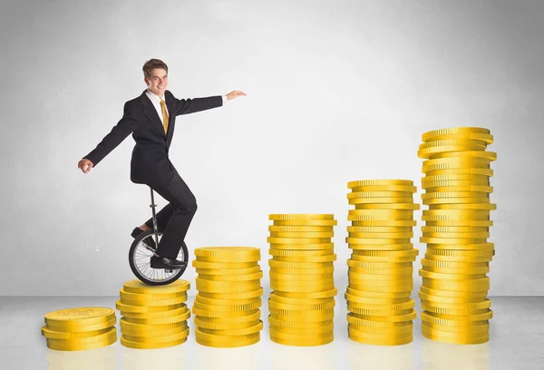 Business man riding monocycle up on coin graph — Stock Photo, Image