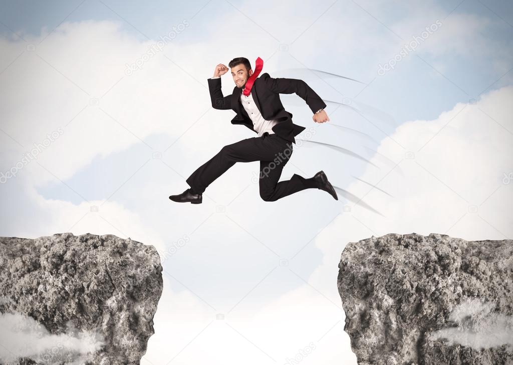 Funny business man jumping over rocks with gap