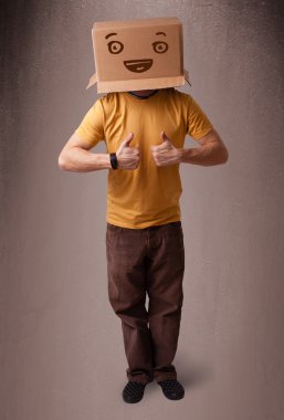genç adam smiley ile kafasına bir karton kutu ile el hareketi